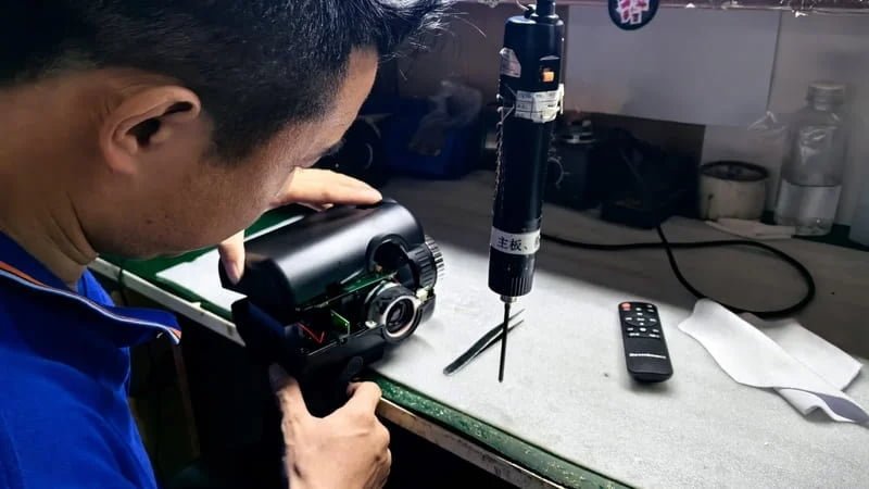 An engineer testing motor noise levels on star projectors during quality inspection using a decibel meter