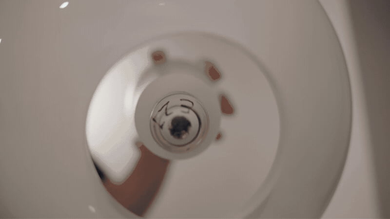 Hand screwing the aurora projection bulb into a lamp socket