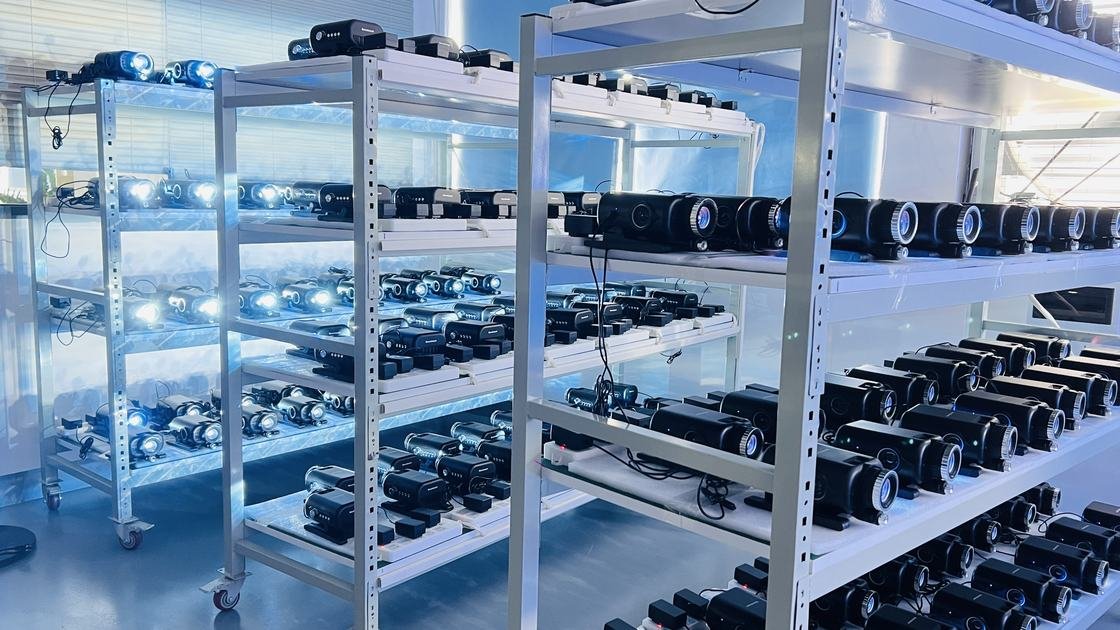 Rows of different projector bodies visibly operating on factory racks