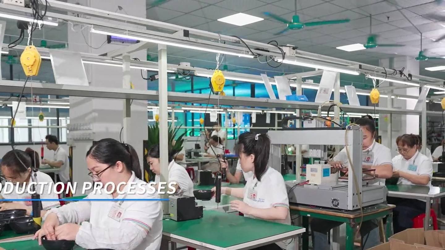 Wide production area with workers, green benches, and overhead fixtures