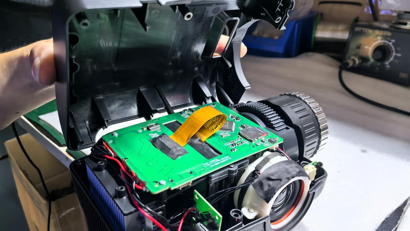 Open Bowlum projector showing circuit board and optical assembly during inspection